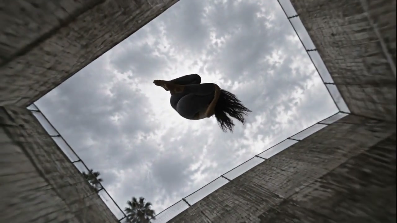 A woman airborne, shot from below